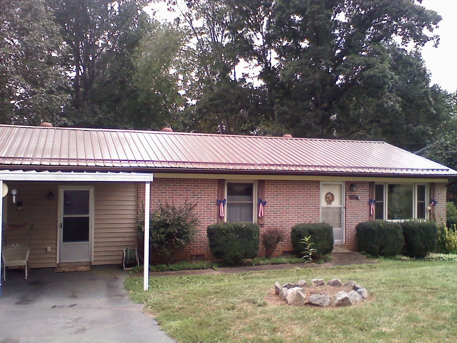 Bronze metal roof and carport on a brick ranch home — Roof Repair work by our crew in Cortez